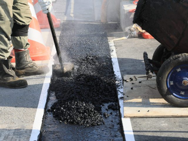 アスファルト舗装の補修施工を行う作業員の手元