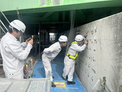 トンネル内で点検作業を行う3名の社員