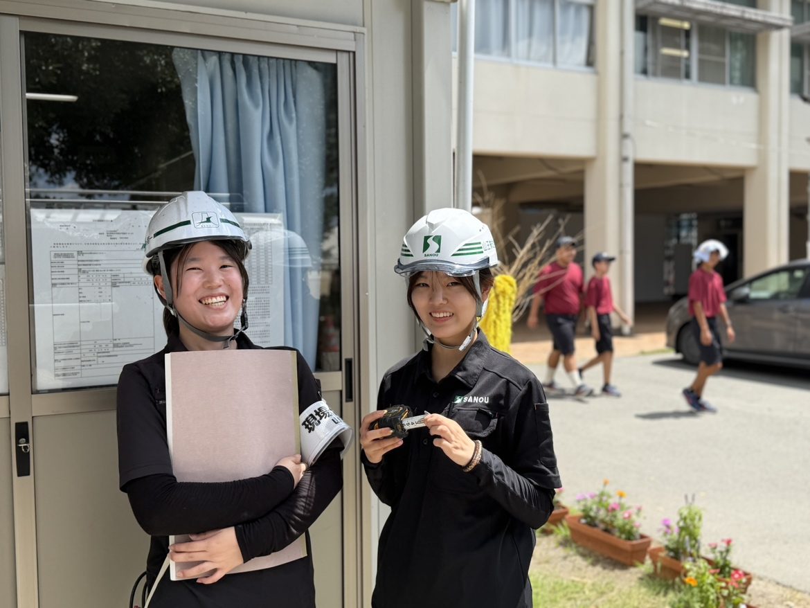 建設現場でヘルメットを着けて働く若手社員