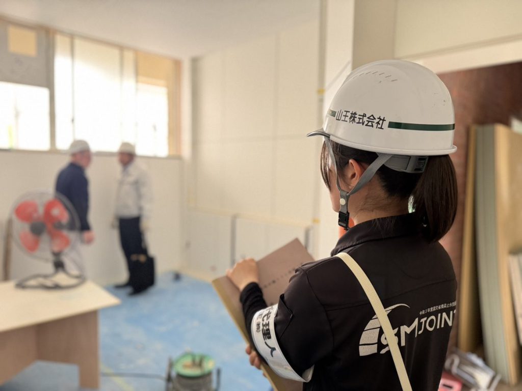 建築現場でヘルメットを着けて仕事に向かう社員